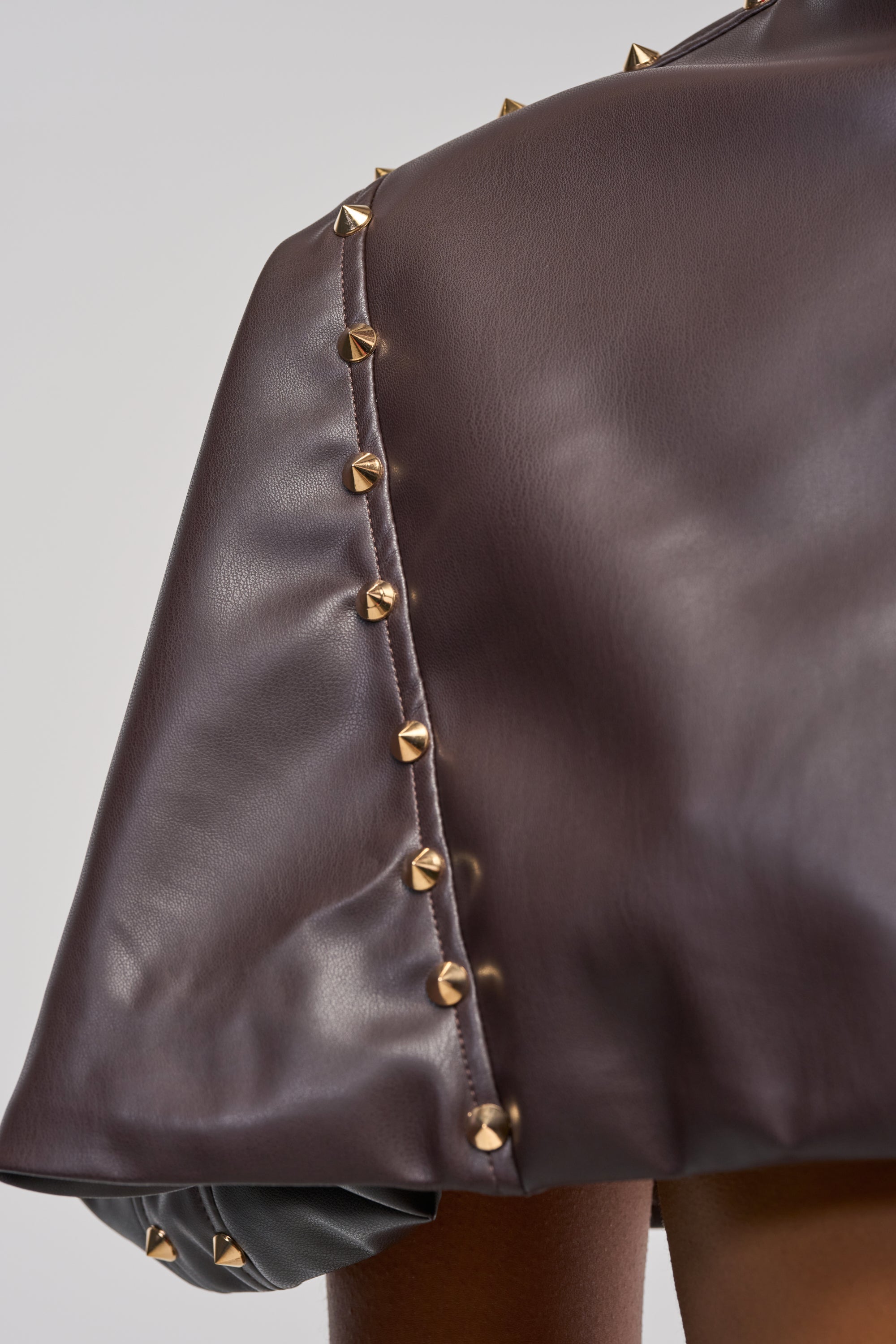 STUDDED FAUX LEATHER CAPE IN DARK CHOCOLATE
